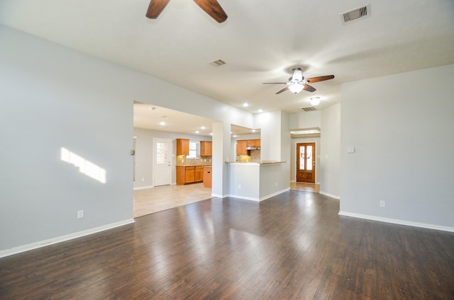 unfurnished living room featuring ceiling fan and hardwood / wood-style floors