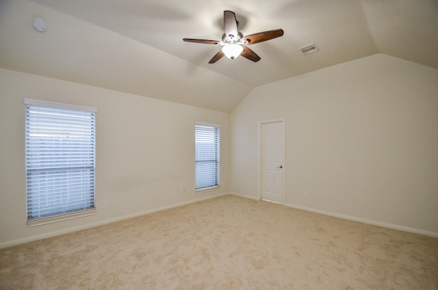 carpeted spare room featuring lofted ceiling and ceiling fan