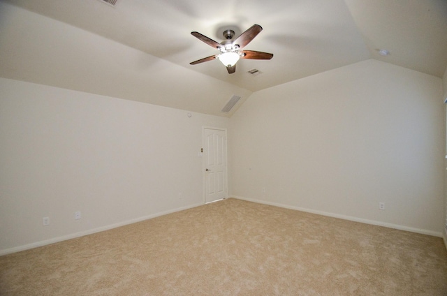 spare room featuring ceiling fan, vaulted ceiling, and light carpet