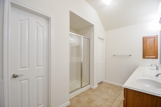 bathroom with vanity, lofted ceiling, tile patterned floors, and a shower with shower door