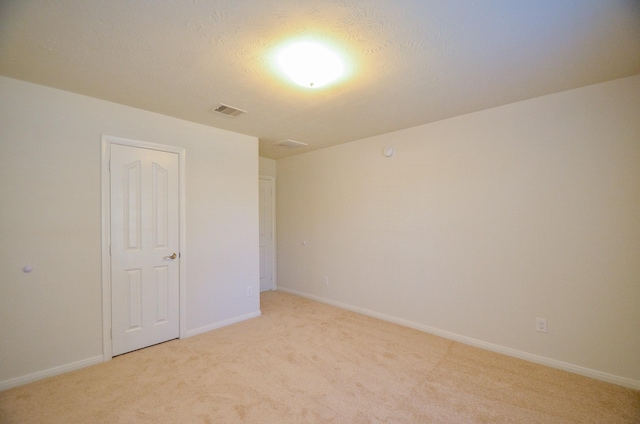 carpeted empty room with a textured ceiling