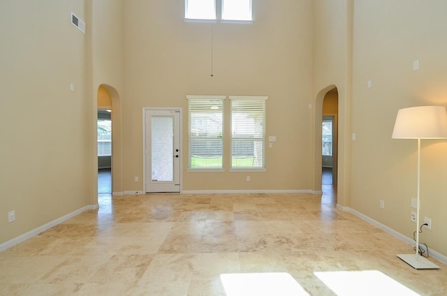 interior space featuring a high ceiling and a healthy amount of sunlight