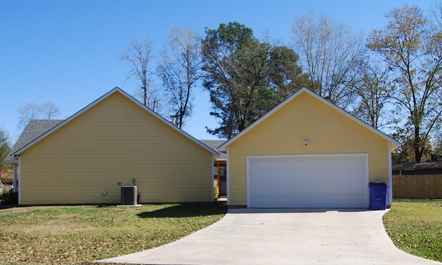 single story home featuring a front yard, central AC, an outbuilding, and a garage