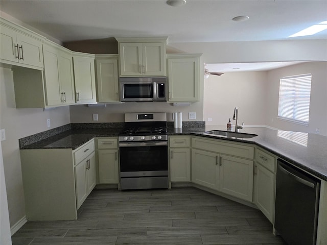 kitchen featuring ceiling fan, appliances with stainless steel finishes, kitchen peninsula, and sink