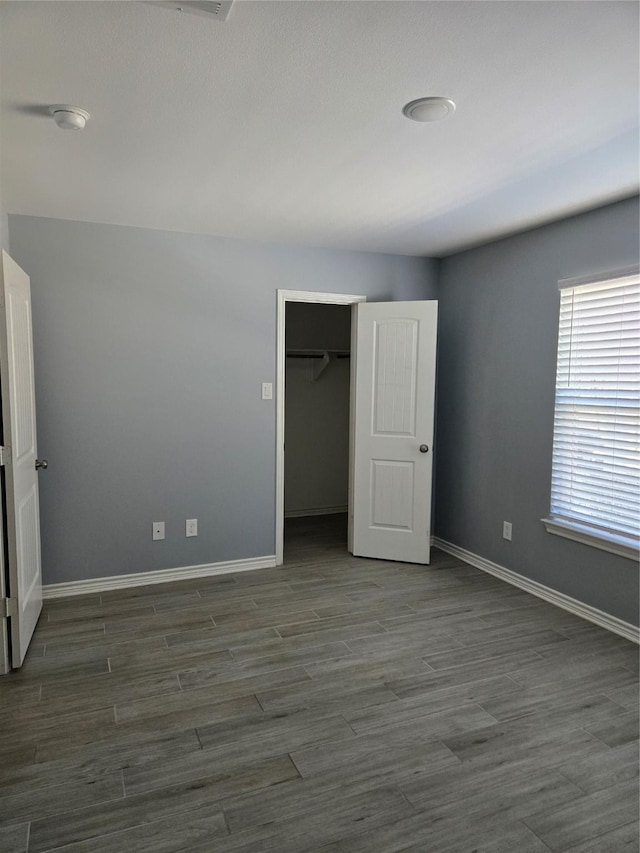 unfurnished bedroom featuring dark wood-type flooring and a closet