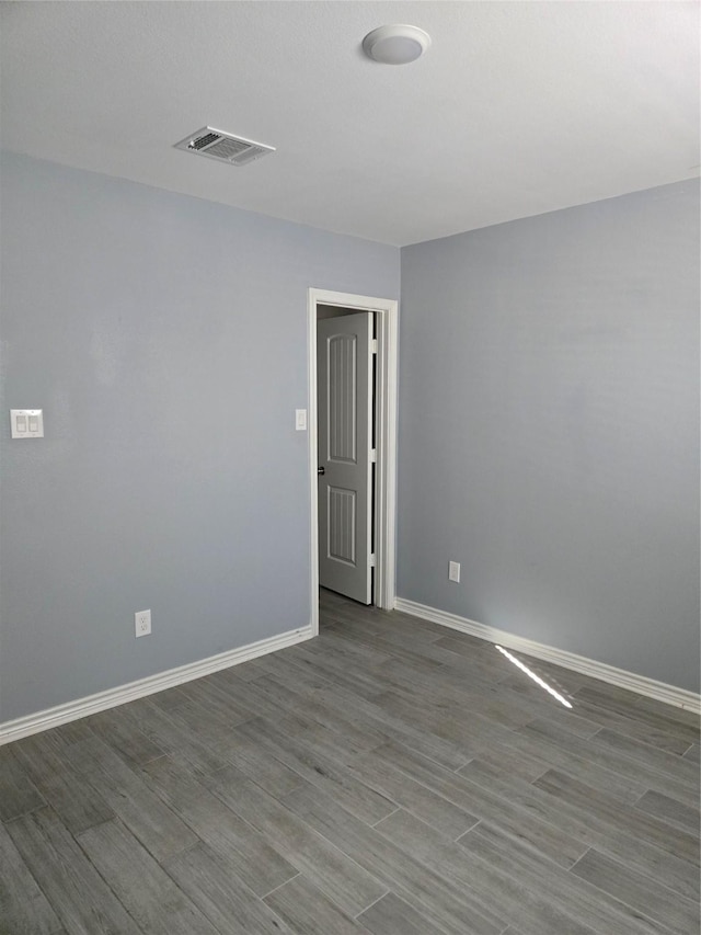 spare room featuring wood-type flooring