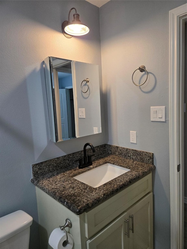 bathroom featuring toilet and vanity