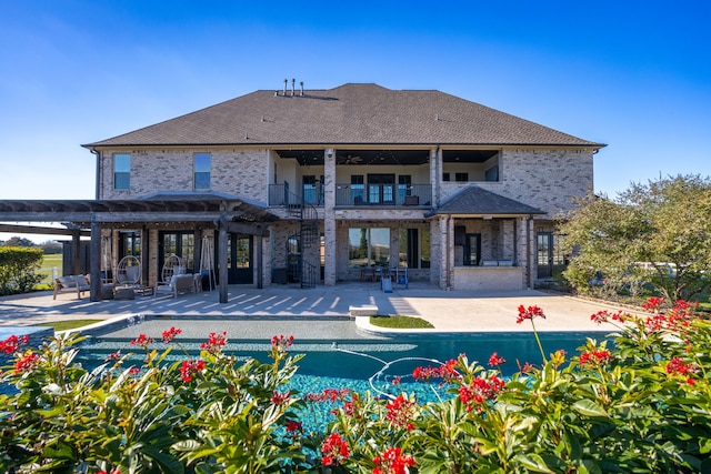 back of property with a pergola, a balcony, and a patio