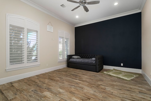 living area featuring ceiling fan, wood-type flooring, and crown molding