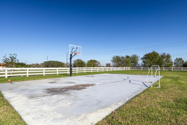 view of basketball court featuring a yard and a rural view