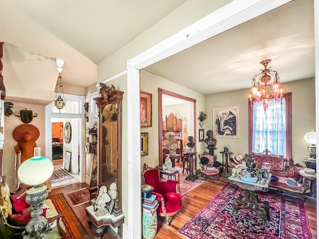 living room featuring wood-type flooring, lofted ceiling, and a notable chandelier