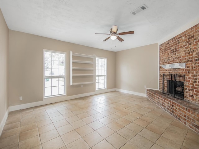 unfurnished living room with ceiling fan, light tile patterned floors, and a fireplace