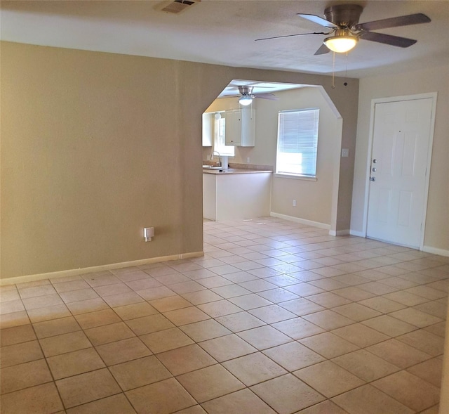 tiled empty room featuring ceiling fan and sink