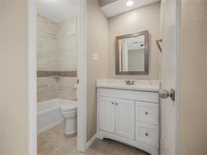 full bathroom with toilet, vanity, and tiled shower / bath