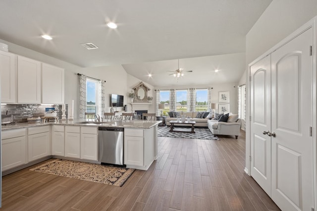 kitchen with dishwasher, white cabinetry, kitchen peninsula, vaulted ceiling, and ceiling fan