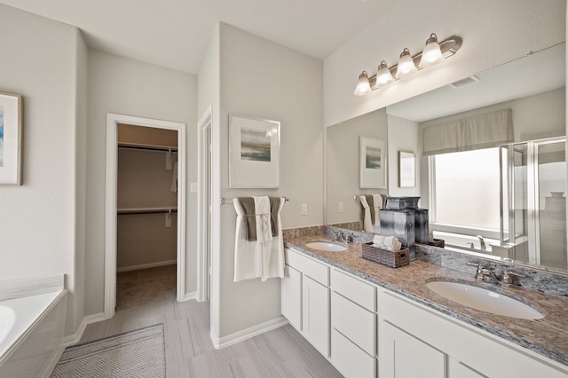 bathroom with vanity and independent shower and bath