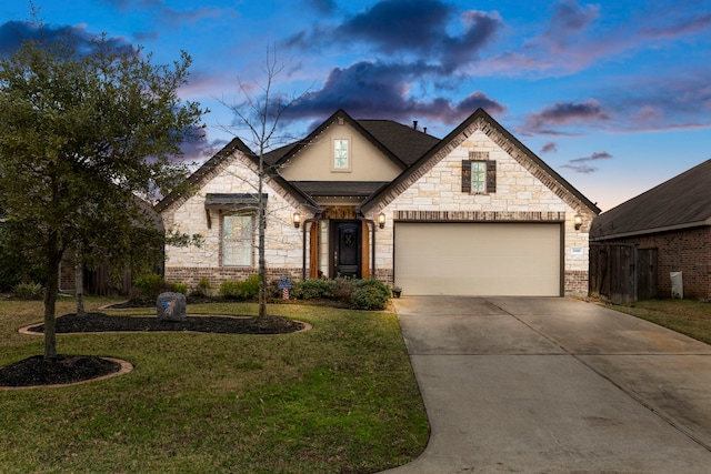 french country home featuring a garage and a lawn