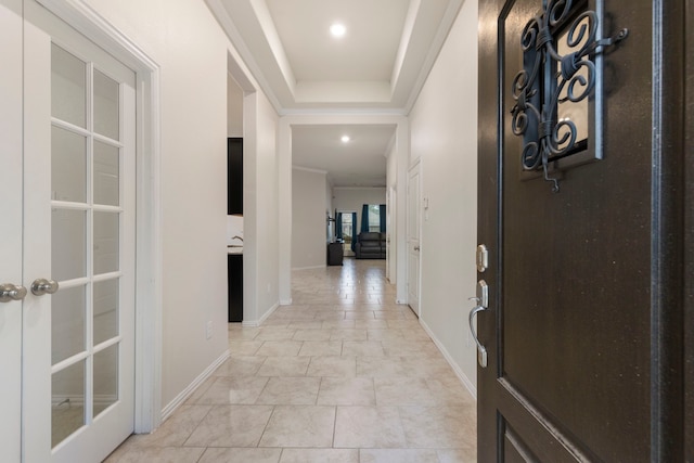 corridor with french doors and a tray ceiling