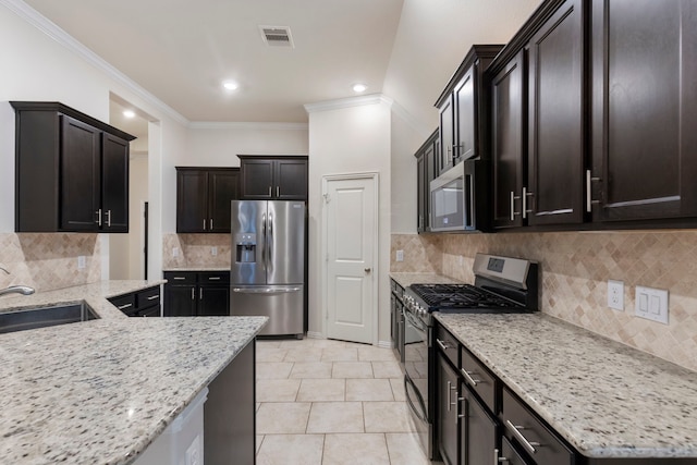 kitchen featuring stainless steel appliances, decorative backsplash, light stone counters, and sink