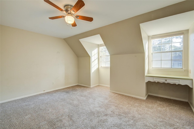 additional living space featuring vaulted ceiling, light colored carpet, and ceiling fan