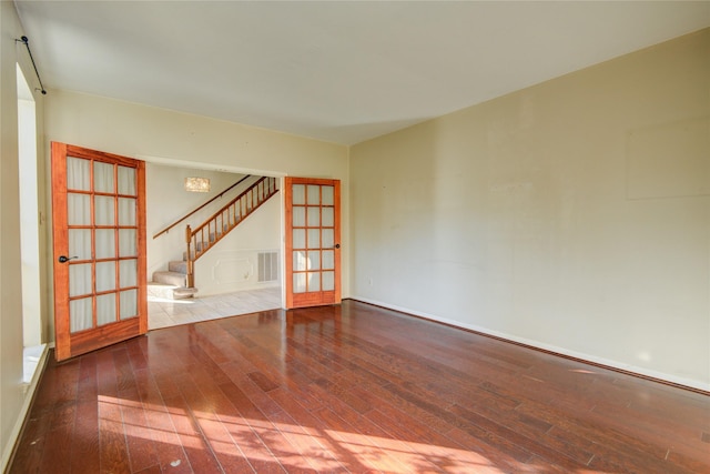 spare room with hardwood / wood-style floors and french doors