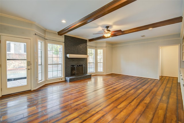 unfurnished living room featuring crown molding, a brick fireplace, dark wood-type flooring, and ceiling fan