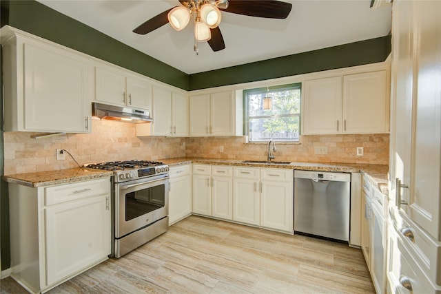 kitchen featuring sink, ceiling fan, appliances with stainless steel finishes, white cabinetry, and light stone counters