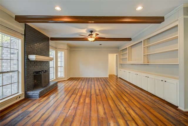 unfurnished living room featuring dark hardwood / wood-style flooring, a brick fireplace, crown molding, and ceiling fan