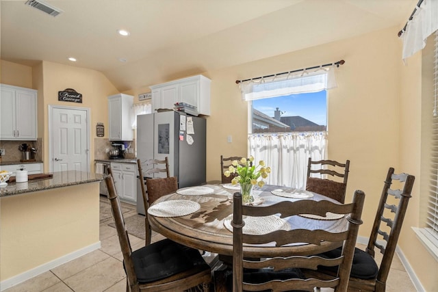 dining room with lofted ceiling and light tile patterned flooring