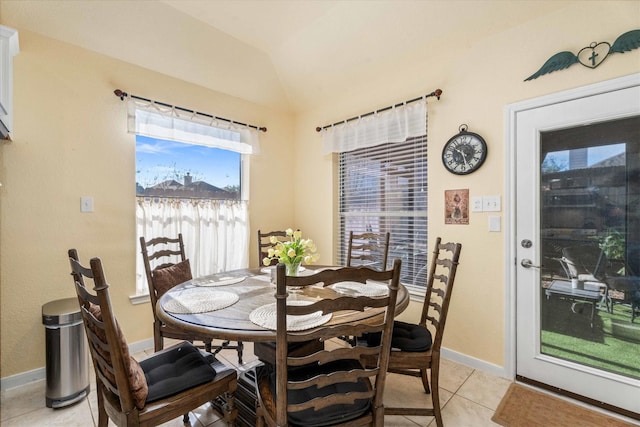 tiled dining space with lofted ceiling