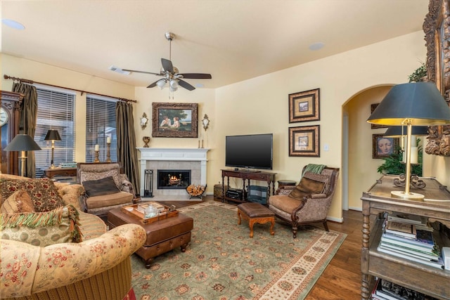 living room featuring a fireplace, ceiling fan, and dark hardwood / wood-style flooring