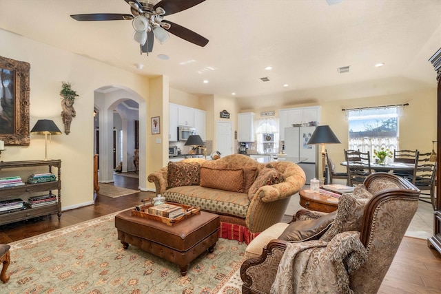 living room with ceiling fan and dark hardwood / wood-style flooring