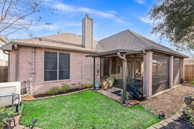 rear view of property with a sunroom and a yard