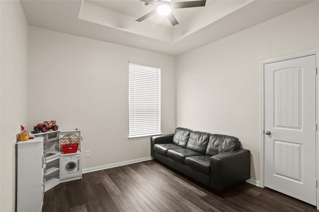 sitting room featuring ceiling fan, dark hardwood / wood-style flooring, and a raised ceiling