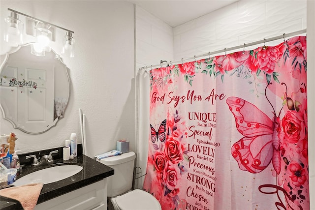 bathroom featuring toilet, walk in shower, and vanity