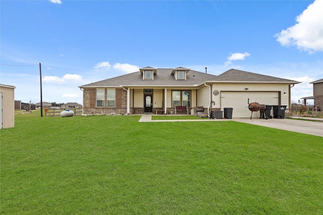 view of front of home with a front yard, covered porch, and a garage