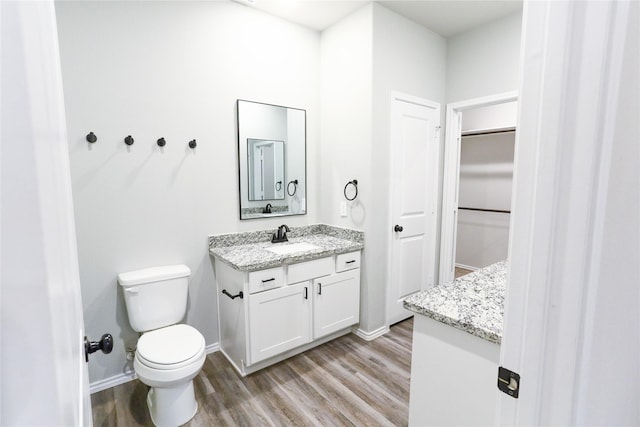 bathroom with hardwood / wood-style floors, toilet, and vanity