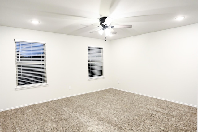 carpeted spare room featuring ceiling fan