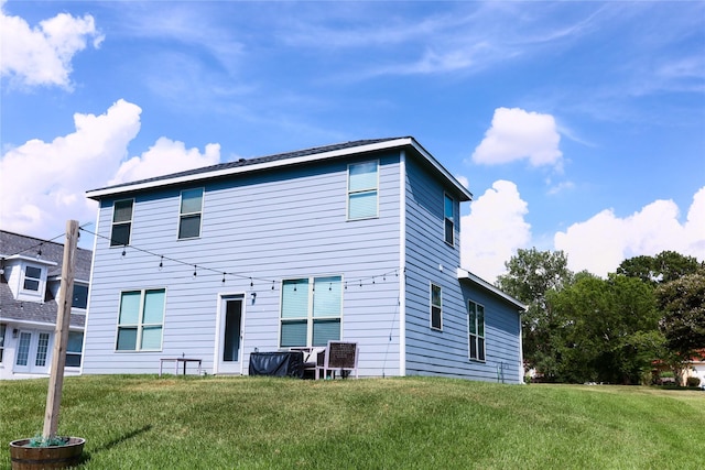 rear view of property featuring a lawn