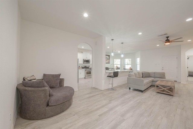 living room featuring ceiling fan and light hardwood / wood-style flooring