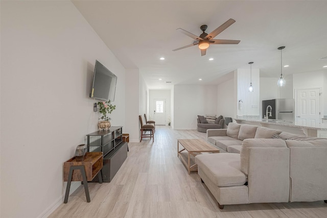 living room featuring light hardwood / wood-style floors and ceiling fan