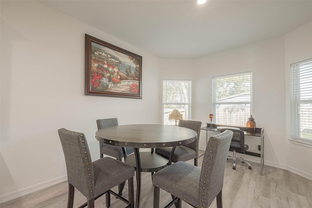 dining area with light hardwood / wood-style floors and a wealth of natural light