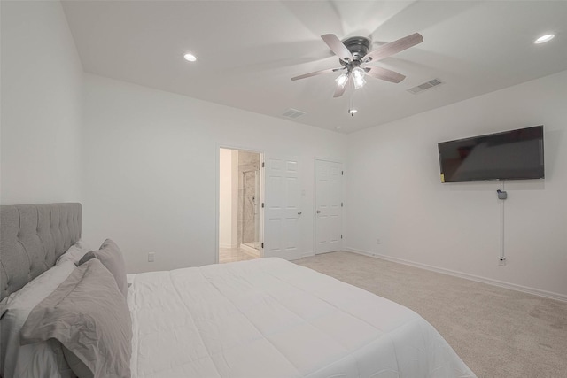 bedroom featuring ceiling fan, ensuite bath, and light carpet