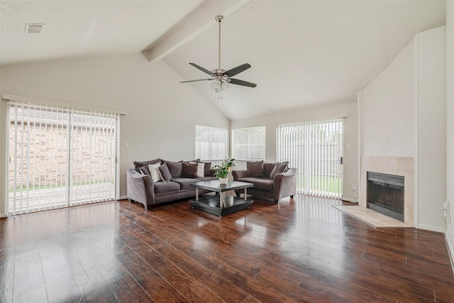 living area featuring beam ceiling, visible vents, a fireplace, and wood finished floors