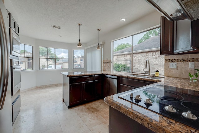 kitchen featuring visible vents, a sink, tasteful backsplash, stainless steel appliances, and dark brown cabinetry