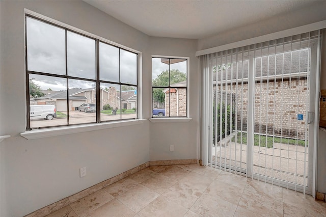 unfurnished room with baseboards