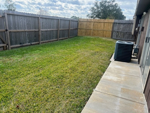 view of yard with central air condition unit and a fenced backyard