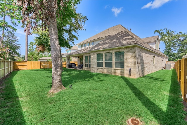 back of property featuring brick siding, a lawn, and a fenced backyard