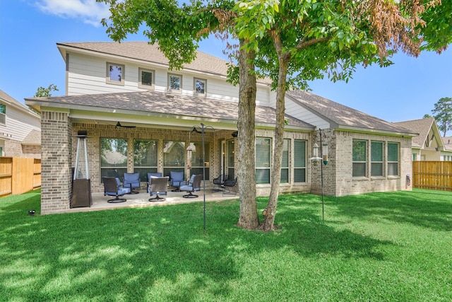 rear view of property with ceiling fan, a lawn, and a patio area