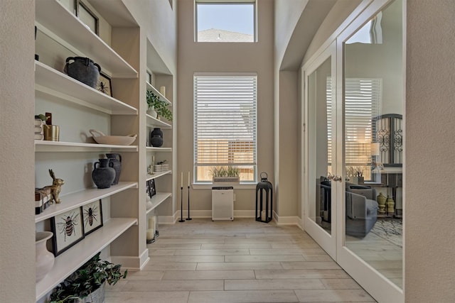 interior space featuring baseboards and light wood finished floors